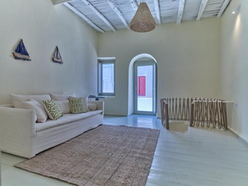 纳乌萨Flair Naousa的客厅配有白色沙发和地毯。