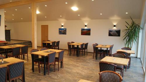 霍费德冰川世界 - 霍费尔住宿加早餐旅馆的用餐室配有木桌和椅子