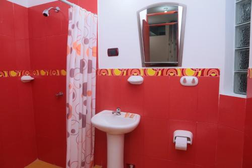 塔拉波托Flor del Valle的红色的浴室设有水槽和镜子