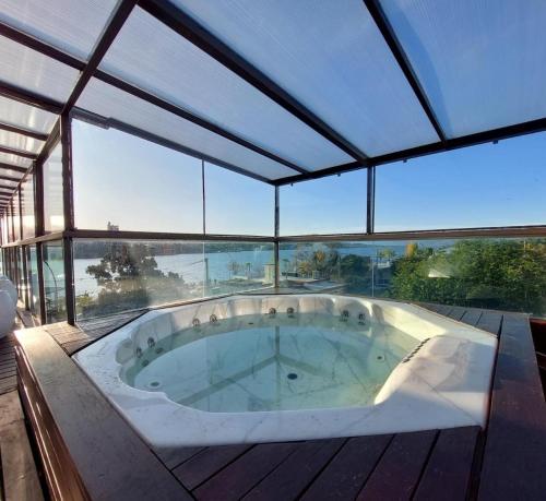 维拉卡洛斯帕兹Costalago Suites的窗户客房内的大型按摩浴缸