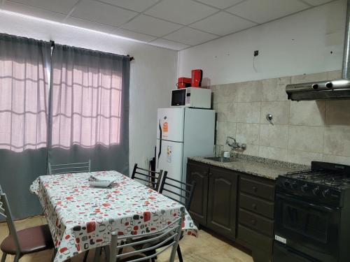 马拉圭Rosetta的厨房配有桌子和白色冰箱。