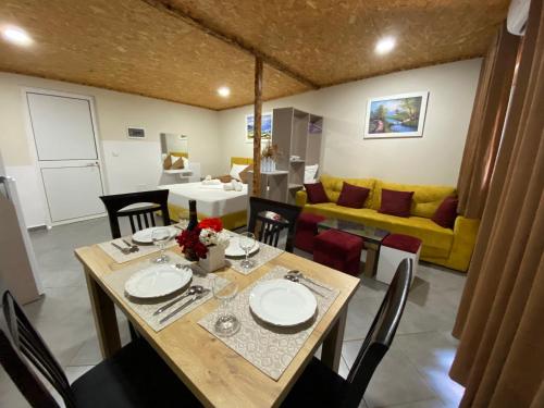 卡萨米尔Full Moon Apartments的一间带桌子和黄色沙发的用餐室