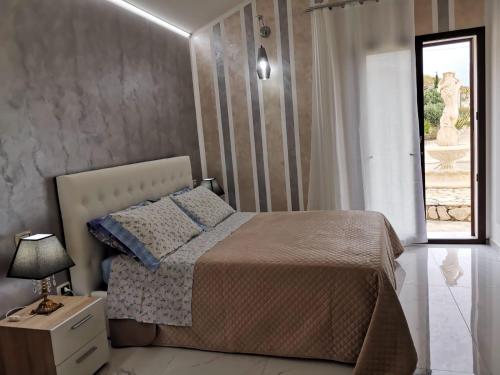 赫拉克勒亚米诺亚La valle degli dei的一间卧室设有一张床和一个窗口