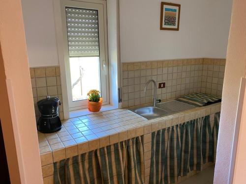 CastelterminiCasa vacanze Sicilia的带水槽的厨房台面和窗户