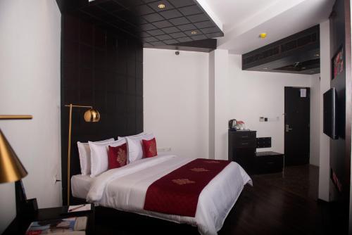 甘托克Ramada by Wyndham Gangtok Hotel & Casino Golden的一间卧室配有一张带红色枕头的大床