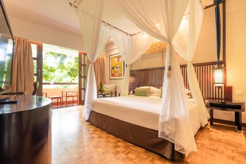 库塔宾当巴厘岛度假村的一间卧室配有一张带天蓬的床