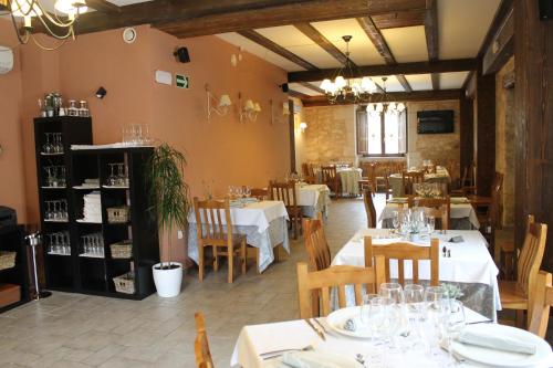 Santa Cruz de la SalcedaHotel Rural Restaurante Las Baronas的一间带白色桌椅的餐厅和一间用餐室