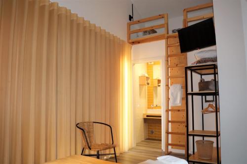 纳扎雷Nazaré Sweet Dreams的一间卧室配有床、椅子和窗帘