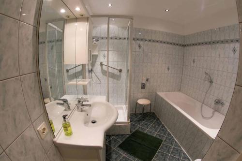瓦豪地区魏森基兴Gästehaus Huber的浴室配有盥洗盆、浴缸和盥洗盆