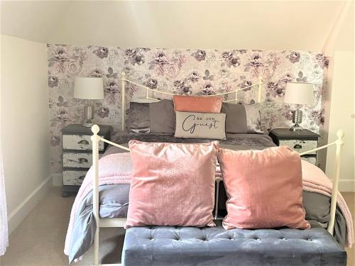 多切斯特The Dairyman Suite的一间卧室配有带粉红色和粉红色枕头的床