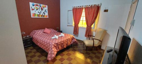 萨尔塔Casa de La Lila的卧室配有床、椅子和窗户。