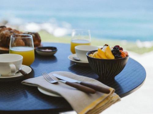 巴利托Sala Beach House的一张桌子,上面放着一碗水果和橙汁