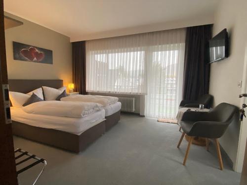 维林根Sevda's Hotel Garni Weinforth的酒店客房配有两张床和一张书桌