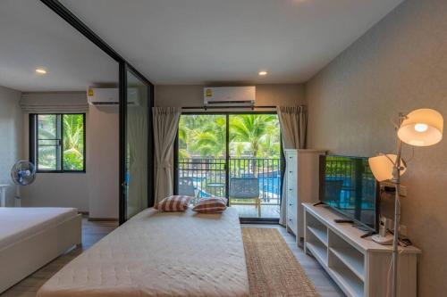 奈扬海滩Title Naiyang residence Excellent location with pool view的一间卧室设有一张大床和一个大窗户
