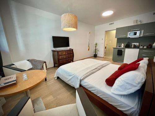 布拉格Harfa Apartment 30的一间卧室配有一张床铺和一张桌子,还设有一间厨房