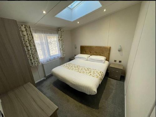 贝塞斯达C05 - The Ogwen Lodge with Hot Tub的一间卧室配有一张带天窗的大床
