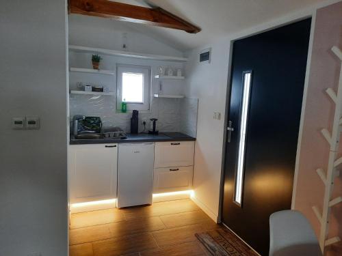 Uherce Mineralne (7)Apartament na górce的厨房配有白色橱柜、水槽和窗户。