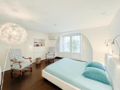 波尔多Appartement 2 chambres avec Terrassse en Hyper centre的一间卧室配有一张床、两把椅子和一个吊灯