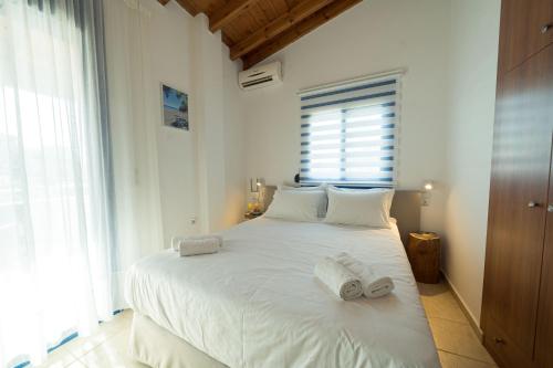 ParánimfoiSunset Home Crete的卧室配有带毛巾的大型白色床