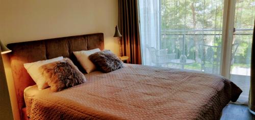 派尔努Aisa 39的卧室配有带枕头的床铺和窗户。