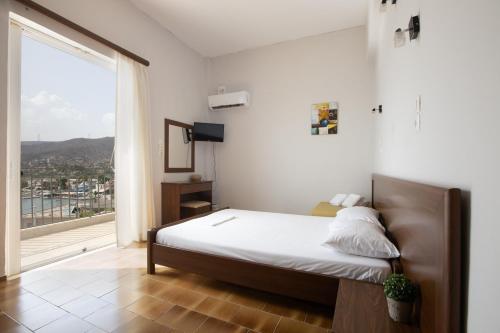 AlikíSeaside apartments的一间卧室设有一张床和一个大窗户