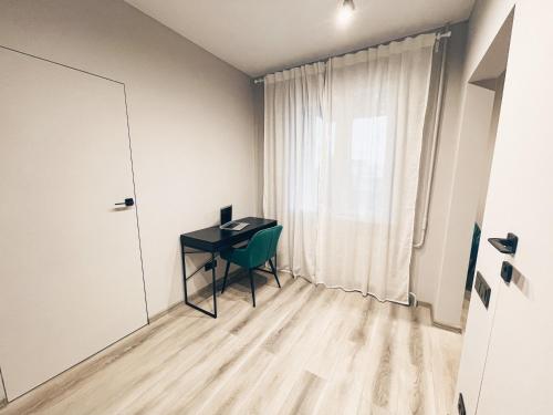 马热伊基艾Pavasario g. apartamentai的小房间设有书桌和窗户