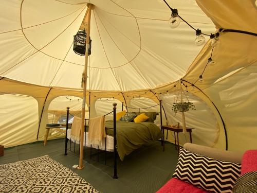 利明顿Secret Garden Glamping的帐篷内一间卧室,配有一张床