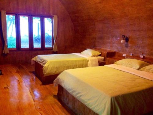 Lang SuanBan Tawansongfa的酒店客房设有两张床和窗户。