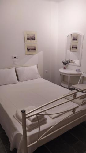 卡利斯托斯Balkonikarystos (To Mpalkoni tis Karistou)的白色卧室配有床和桌子