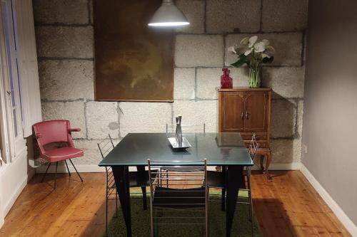 维戈Acogedor apartamento en el Casco Antiguo的餐桌、椅子和花瓶