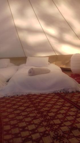 FatacaQuintal Alentejano的帐篷内的白色床和地毯