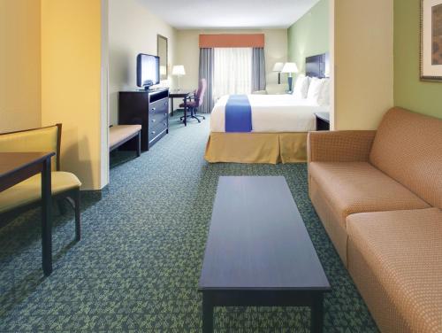Covington科温顿智选假日酒店及套房的酒店客房,配有床和沙发