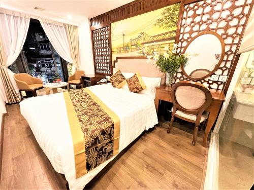河内DE LA SOIE Hotel & Travel的一间卧室配有一张床、一张书桌和一面镜子