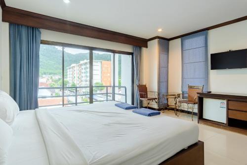 Ban Huai Luk (1)Goodday Kathu的一间卧室设有一张大床和一个大窗户