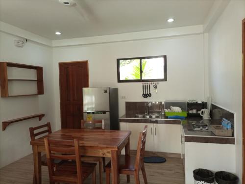 邦劳Portofino Panglao Bohol的厨房配有木桌和冰箱。