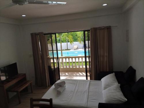 邦劳Portofino Panglao Bohol的一间卧室设有一张床和一个滑动玻璃门