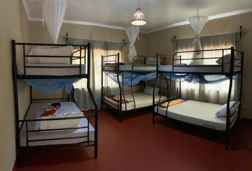 莫希Pazuri Hostel的一间房间,设有三张双层床