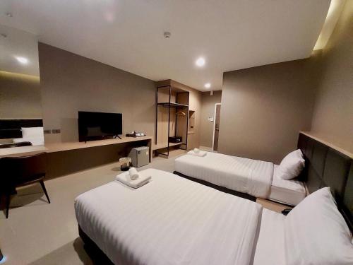 Ban Sok DuaS.R.SUNSHINE HOTEL的酒店客房设有两张床和一台平面电视。