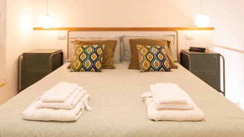 努奥罗Welcomely - Civico 65-40的一间卧室配有带毛巾的床