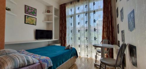 巴统思维里巴图米酒店的一间卧室配有一张床,窗户配有桌子