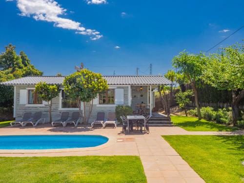 阿尔豪林德拉托里Cubo's Finca Los Ciruelos的一座带游泳池和桌椅的房子