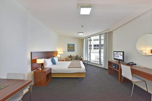 悉尼APX世界广场公寓式酒店的配有一张床和一张书桌的酒店客房