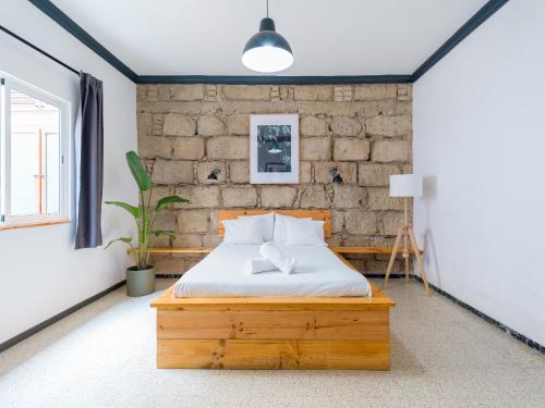大加那利岛拉斯帕尔马斯Cathedral Apartment的一间卧室设有一张床和砖墙