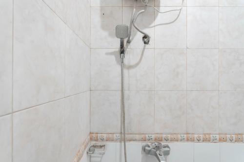 庞岸达兰RedDoorz Plus At Hotel Sofia Pangandaran的白色瓷砖浴室内的淋浴