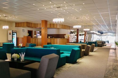 日利纳斯洛伐克酒店 的大楼内带蓝色沙发和桌子的等候室