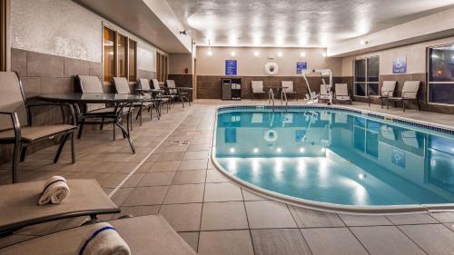 格里利Best Western Greeley的游泳池位于酒店带桌椅的客房内