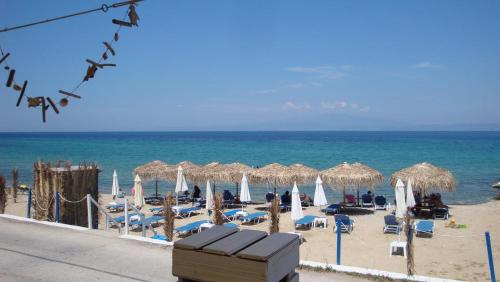 斯卡拉索提罗斯Villa Giotis Suite的海滩上设有遮阳伞和椅子,还有大海