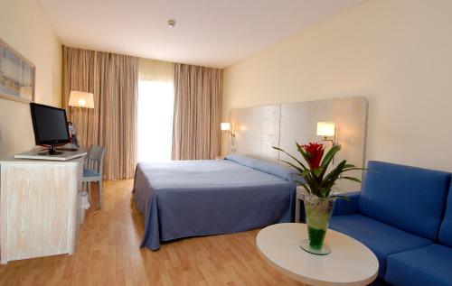 卡耐特蒂贝兰格AGH卡内特酒店的酒店客房,配有床和蓝色的沙发