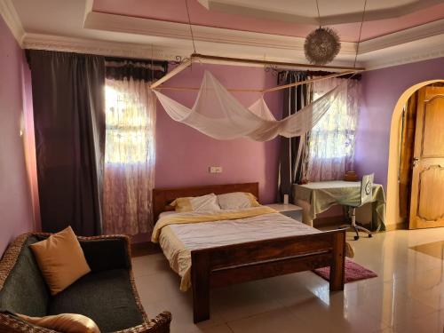 阿鲁沙Villa Jane的一间卧室配有床、椅子和窗帘