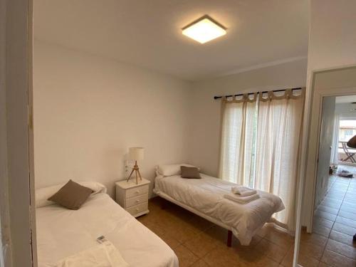 埃斯普霍斯Apartamento para 4-5 personas en es Pujols, Formentera的一间卧室设有两张床和窗户。